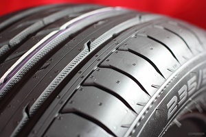 Close-up of black car tire with tread pattern
