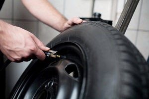 Mechanic deflating vehicle tyre closeup