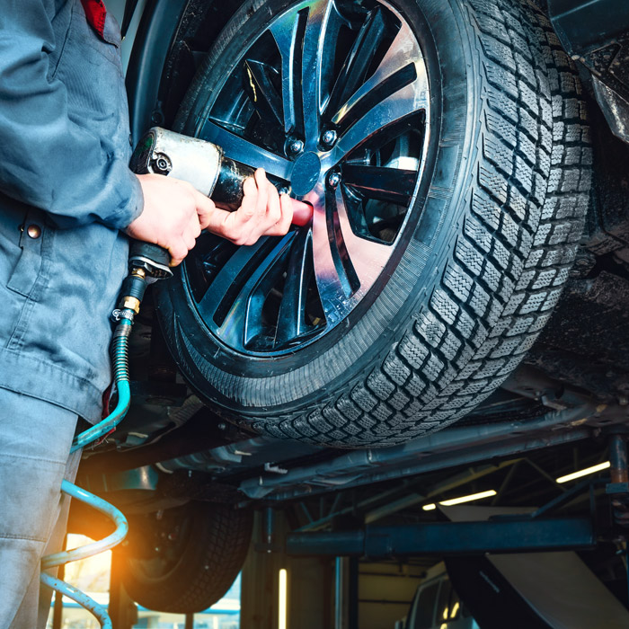 mechanic putting tire on car