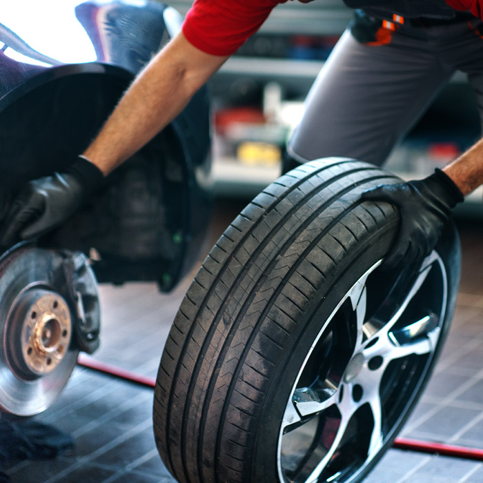 employee putting a new tire on car