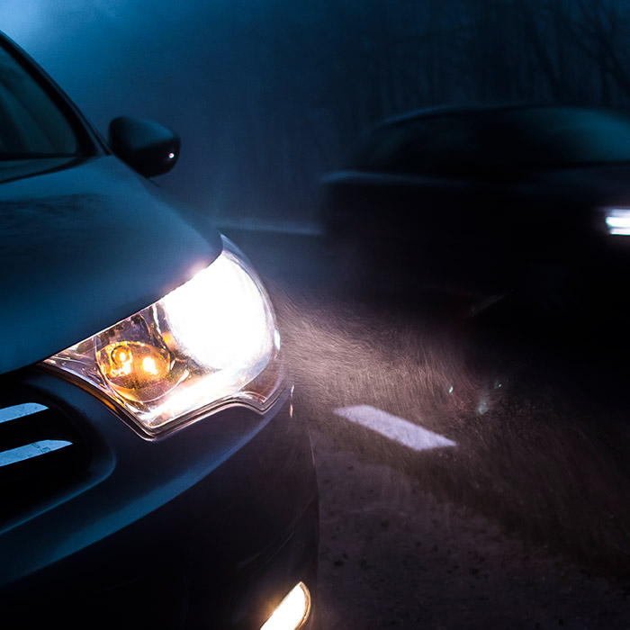 car driving at night with headlights on
